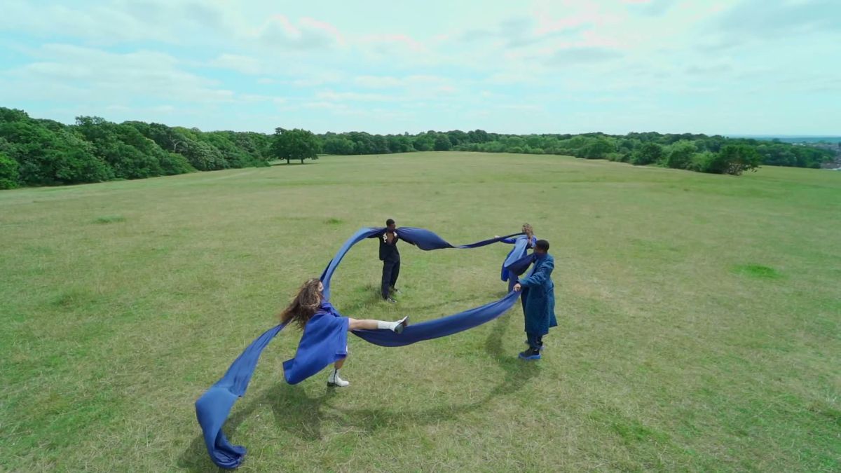 Models linked by long blue fabric ribbons across an open field, 1883 Magazine 2 metres distance