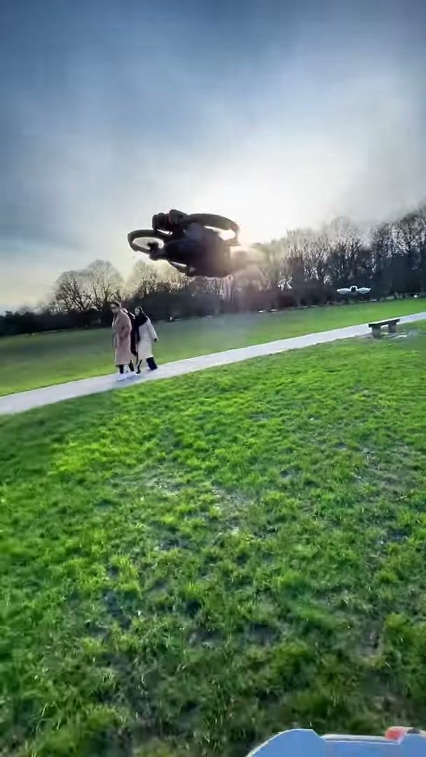 DJI Avata 2 hovering low over open grass in a London park