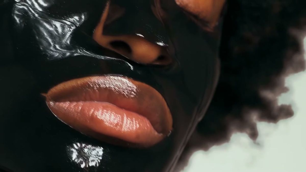 Macro of a glossy black 111SKIN face mask on lips and skin