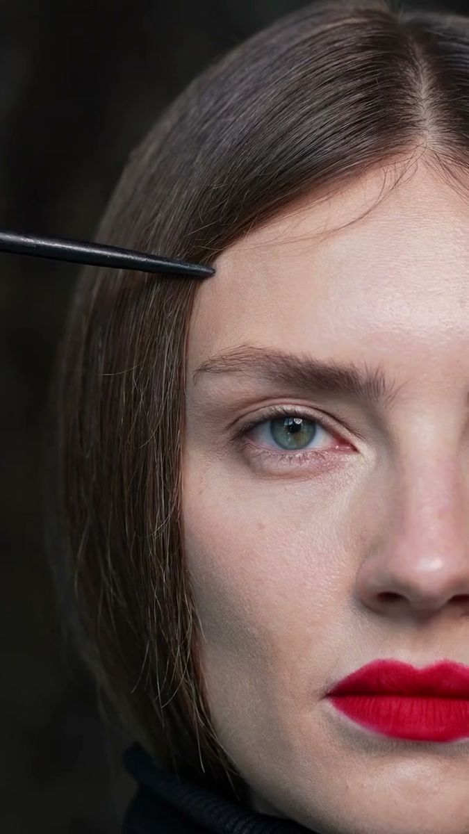 Close-up beauty portrait with a crimson lip, skin texture and freckles kept