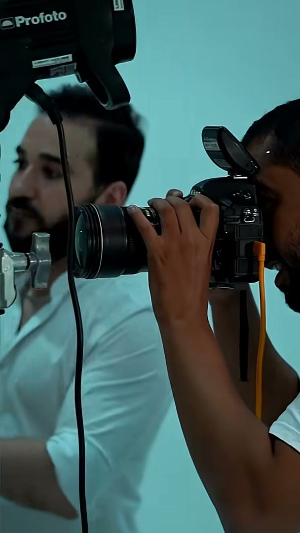 Photographer shooting under a Profoto head on the Charlotte Tilbury set