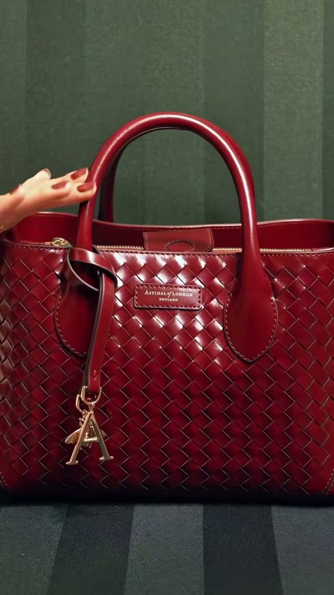 Burgundy woven leather handbag on a dark green velvet set