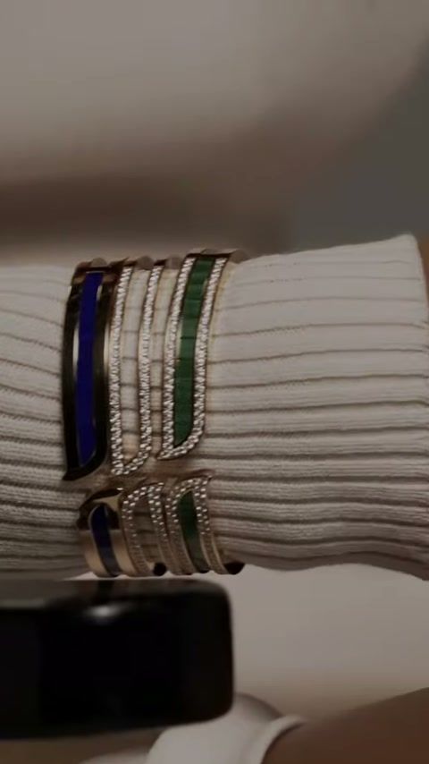 Stacked ALIF by Damas bangles on a cream knit sleeve