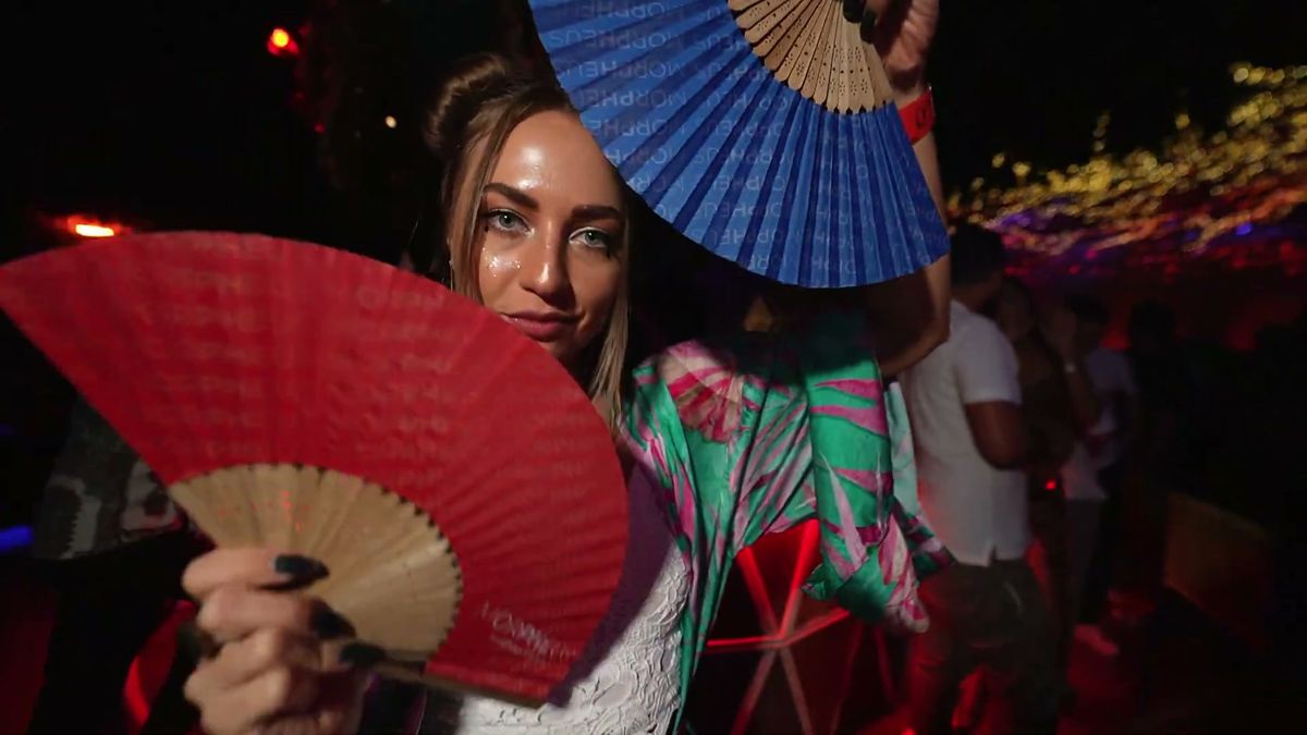 Guests with red and blue fans at a Dubai night event