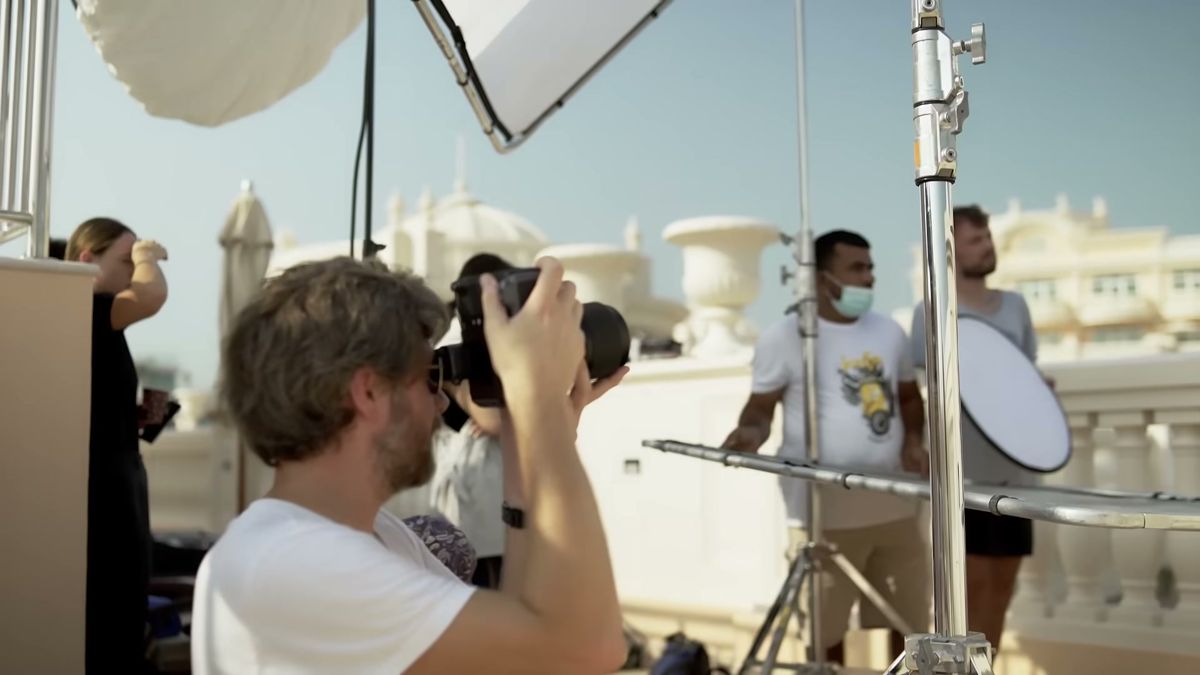 Behind the scenes on a Dubai rooftop set with reflectors and a photographer, Damas