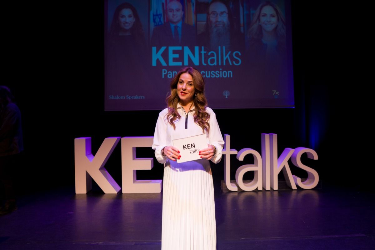 Speaker on stage in front of the KEN talks letters