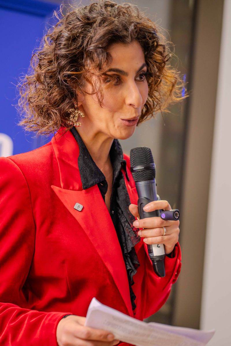 Speaker in a red jacket with a microphone at the L'Atelier Five launch