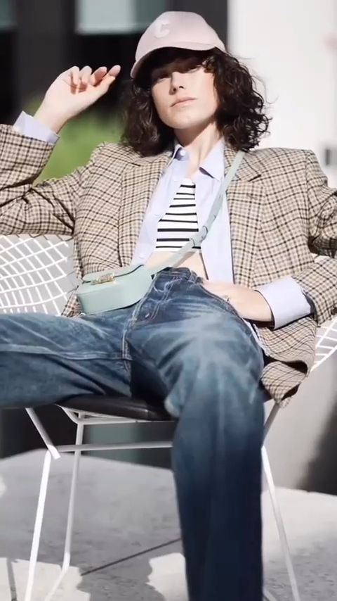 Model in a check blazer, cap and jeans with a mint Celine bag, from the Celine Winter 22 film shot in Dubai