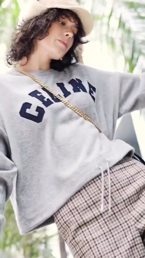 Model in a grey Celine sweatshirt and check trousers with a gold chain bag, Celine Winter 22 film