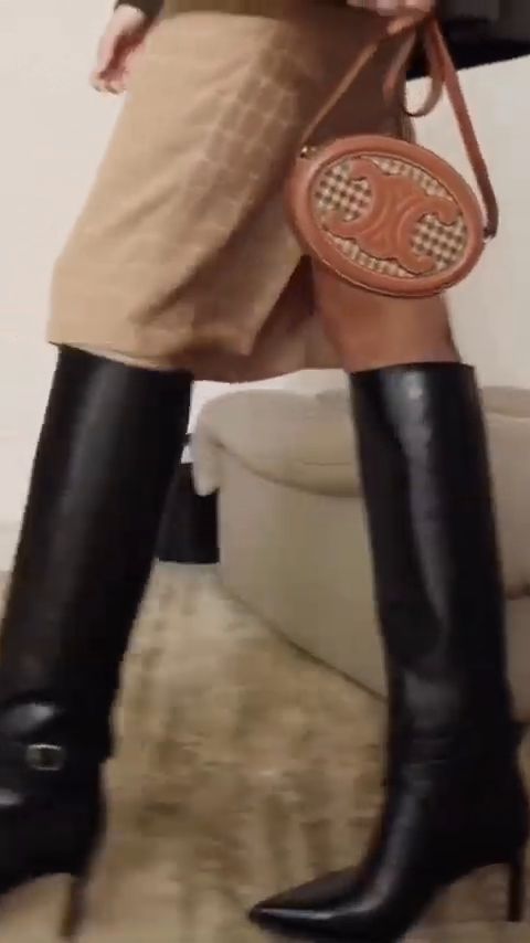 Knee boots and a small Celine bag in motion, from the Celine Winter 22 film
