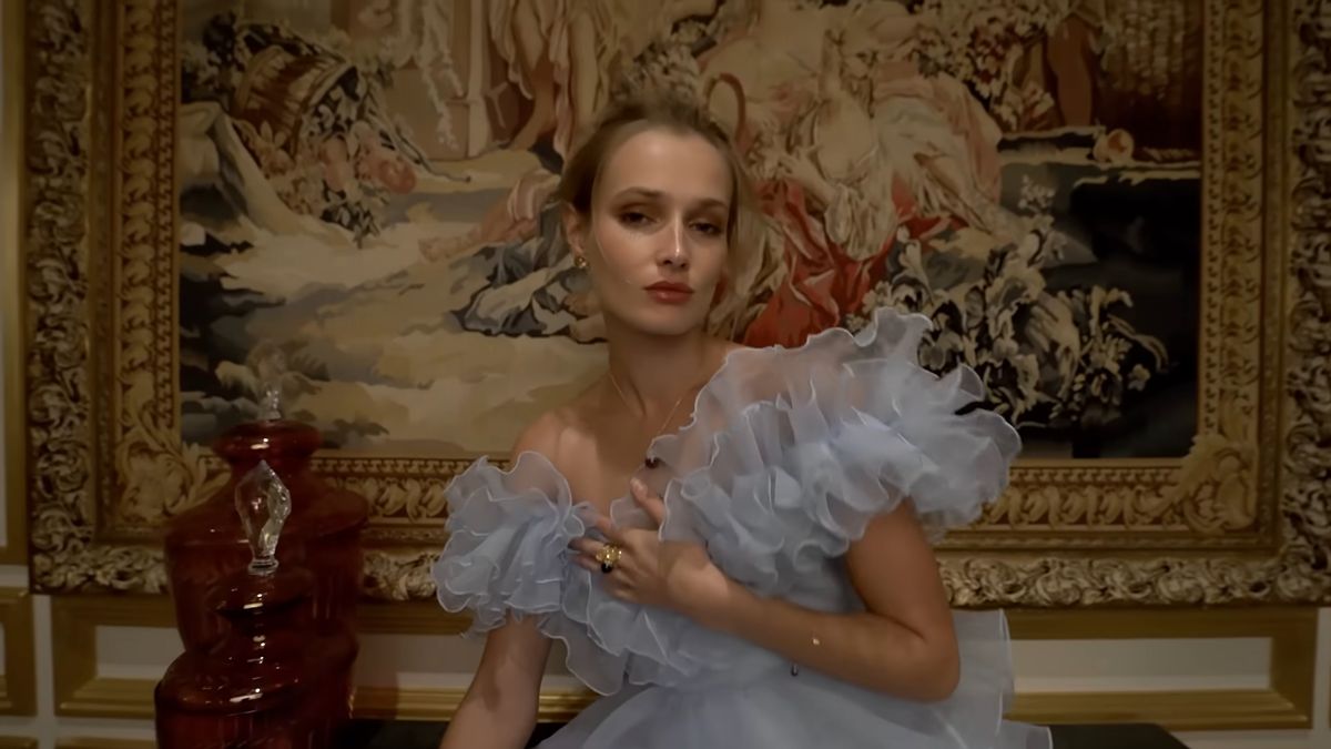 Model in a pale blue tulle gown in a tapestry room, Damas campaign, Dubai