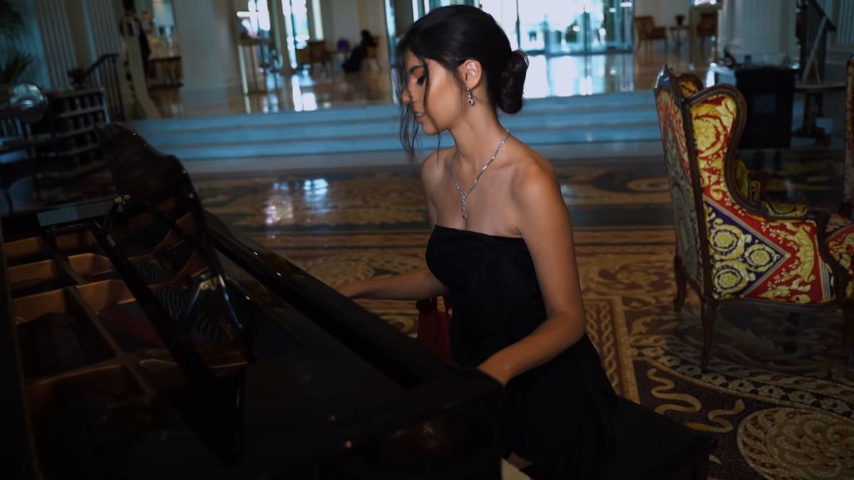 Model at a grand piano in the hotel lounge, L'Officiel Baltic at Palazzo Versace Dubai