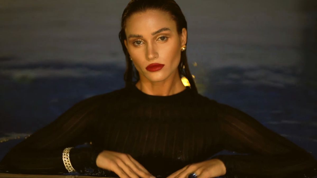 Model at the pool edge at night with a red lip and pearls, Your Water Form, Dubai