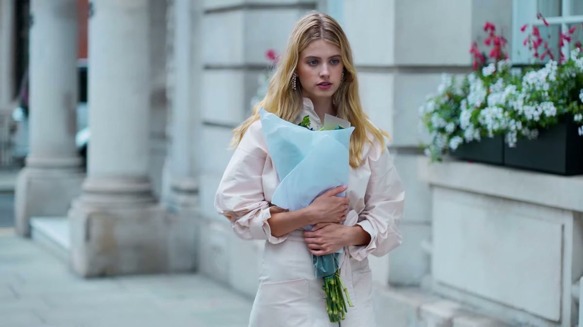 Model in a pale coat holding a bouquet by a stucco portico, Staccato fashion film, London