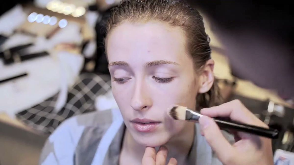 Make-up artist applying foundation backstage at Chalayan, London Fashion Week