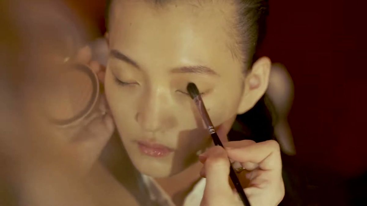 Make-up artist applying eye make-up backstage at Lanvin, Paris
