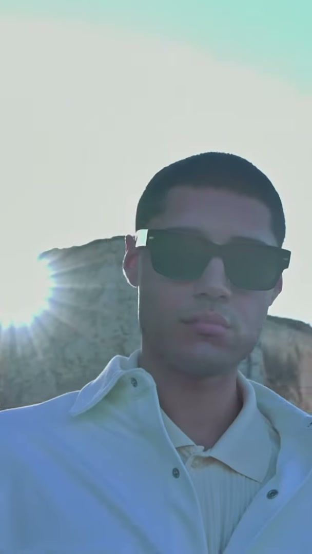 Close FPV shot of a male model in sunglasses and a white shirt