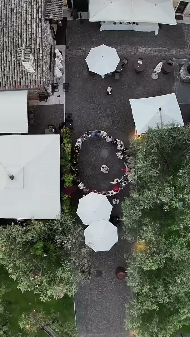 Overhead FPV shot of guests dancing in a courtyard at a wedding near Verona
