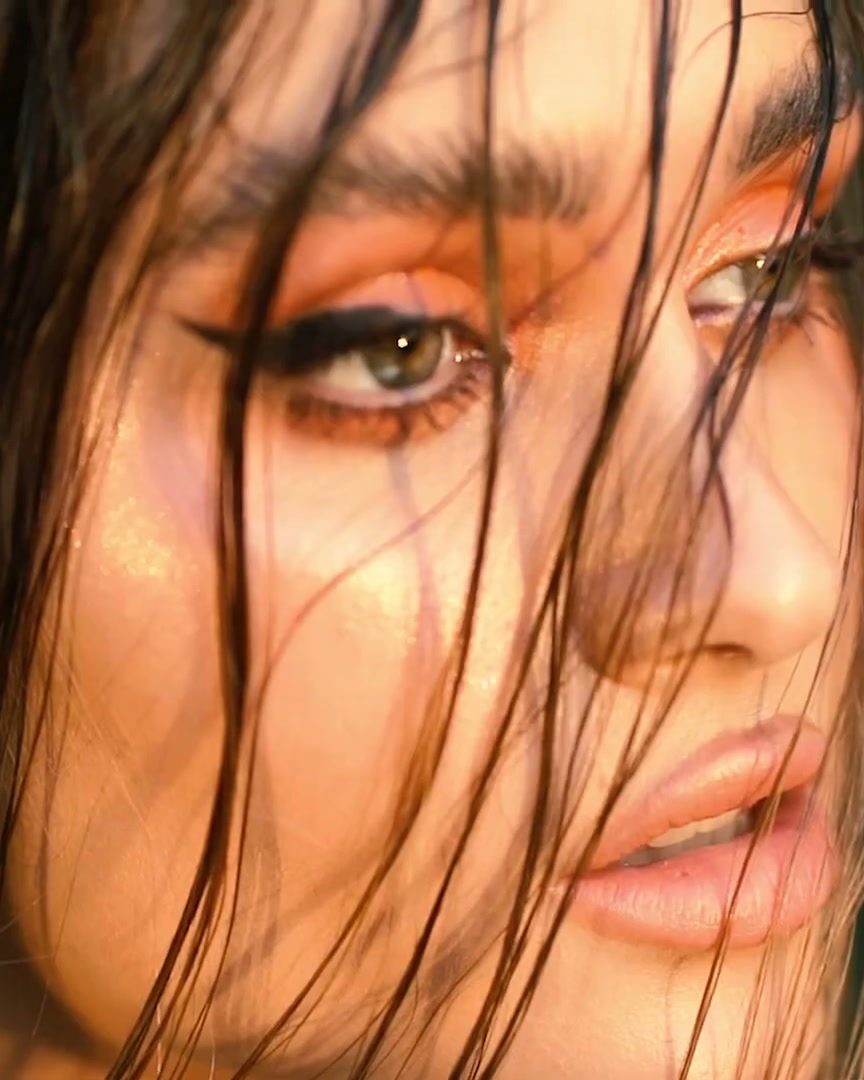 Wet hair strands across a model's face in warm light, Dubai beauty shoot