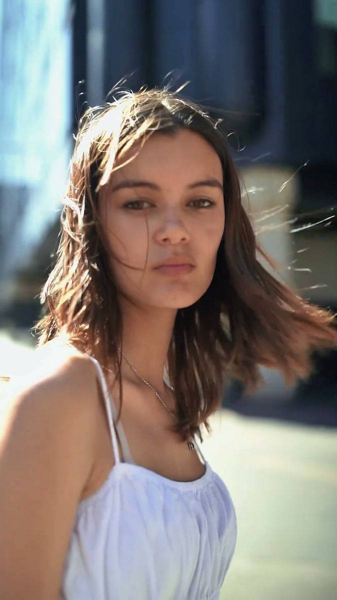 Wind lifting a model's hair in a backlit street portrait