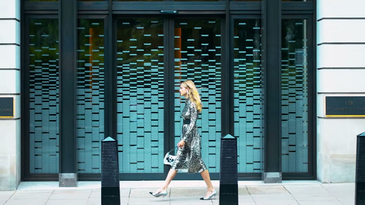 Model walking past a patterned glass facade in London, Staccato footwear commercial