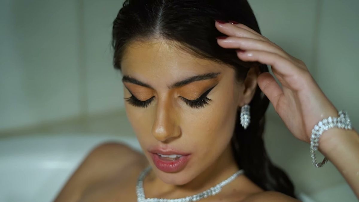 Model in a bath wearing diamond earrings, a necklace and a bracelet in the L'Officiel Baltic film at Palazzo Versace