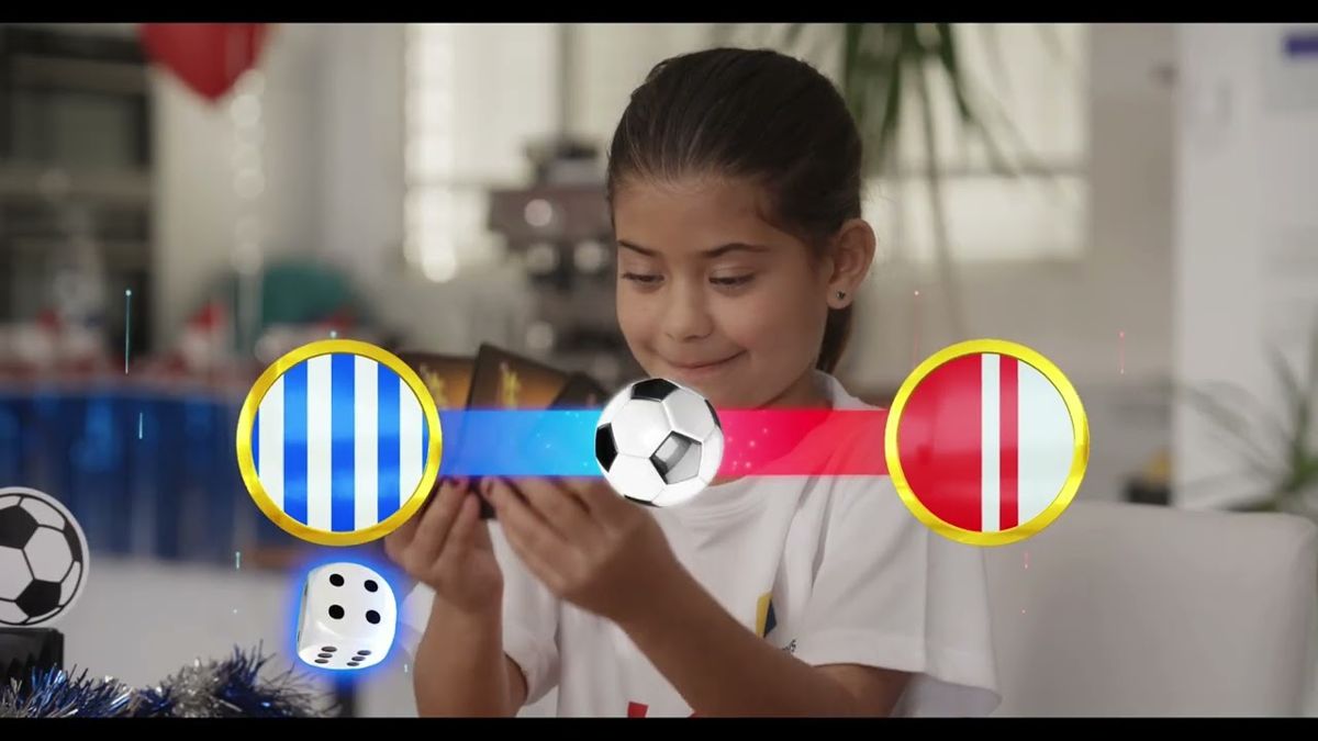 Girl holding a game card with animated team badges, ball and dice graphics over the shot