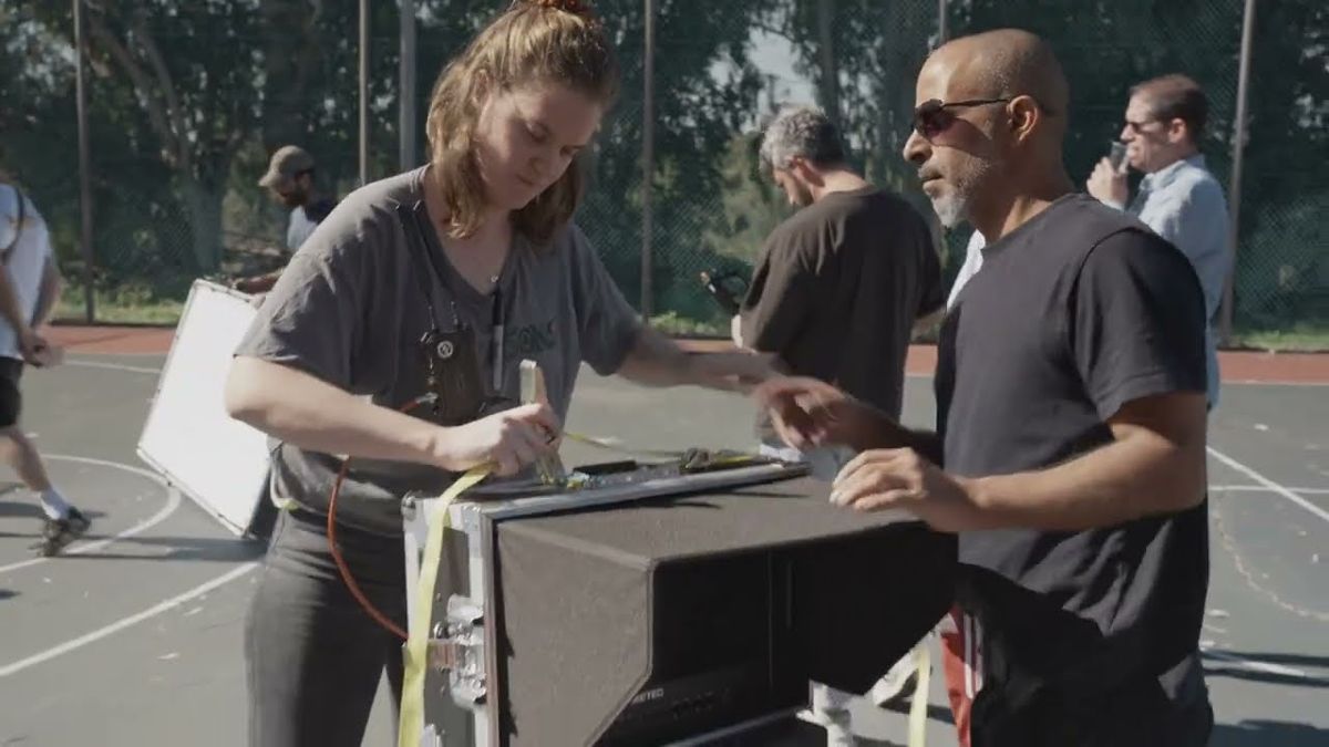 Crew preparing kit on an outdoor court during the KickOff commercial shoot
