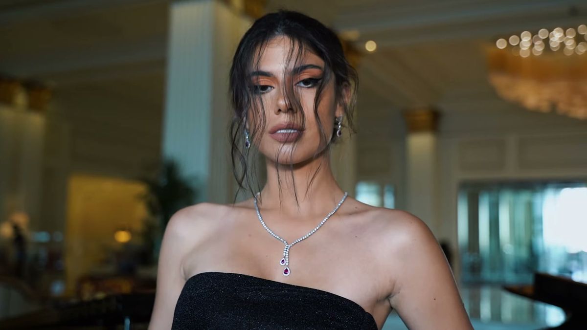 Inès Trocchia in a black strapless dress and diamond necklace in the hotel lobby