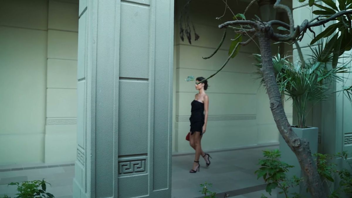 Wide shot of the model at a doorway in the Palazzo Versace Dubai colonnade