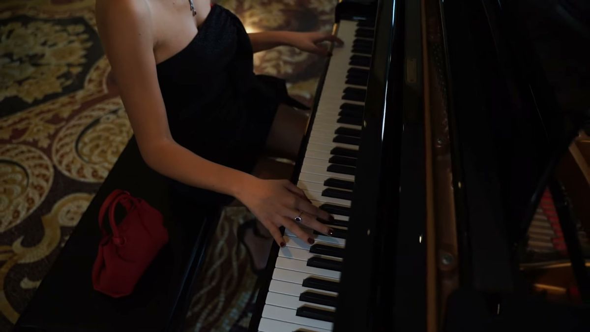 Hands on a grand piano in the Palazzo Versace Dubai lounge