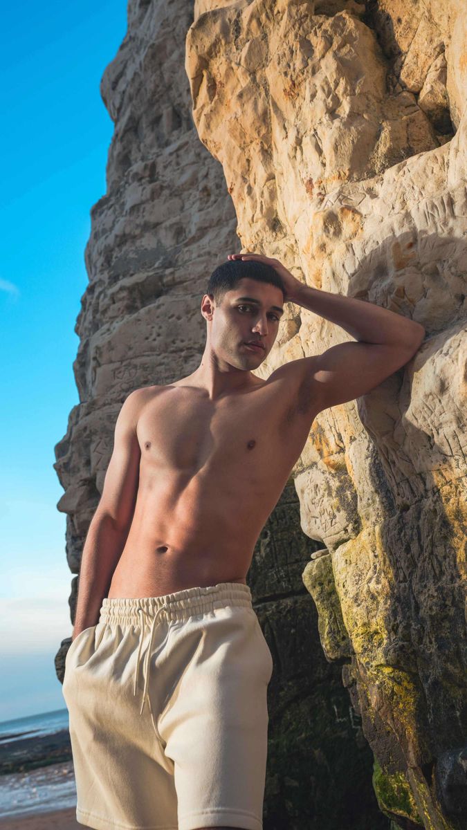 Model leaning against a chalk cliff on the Kent coast under blue sky
