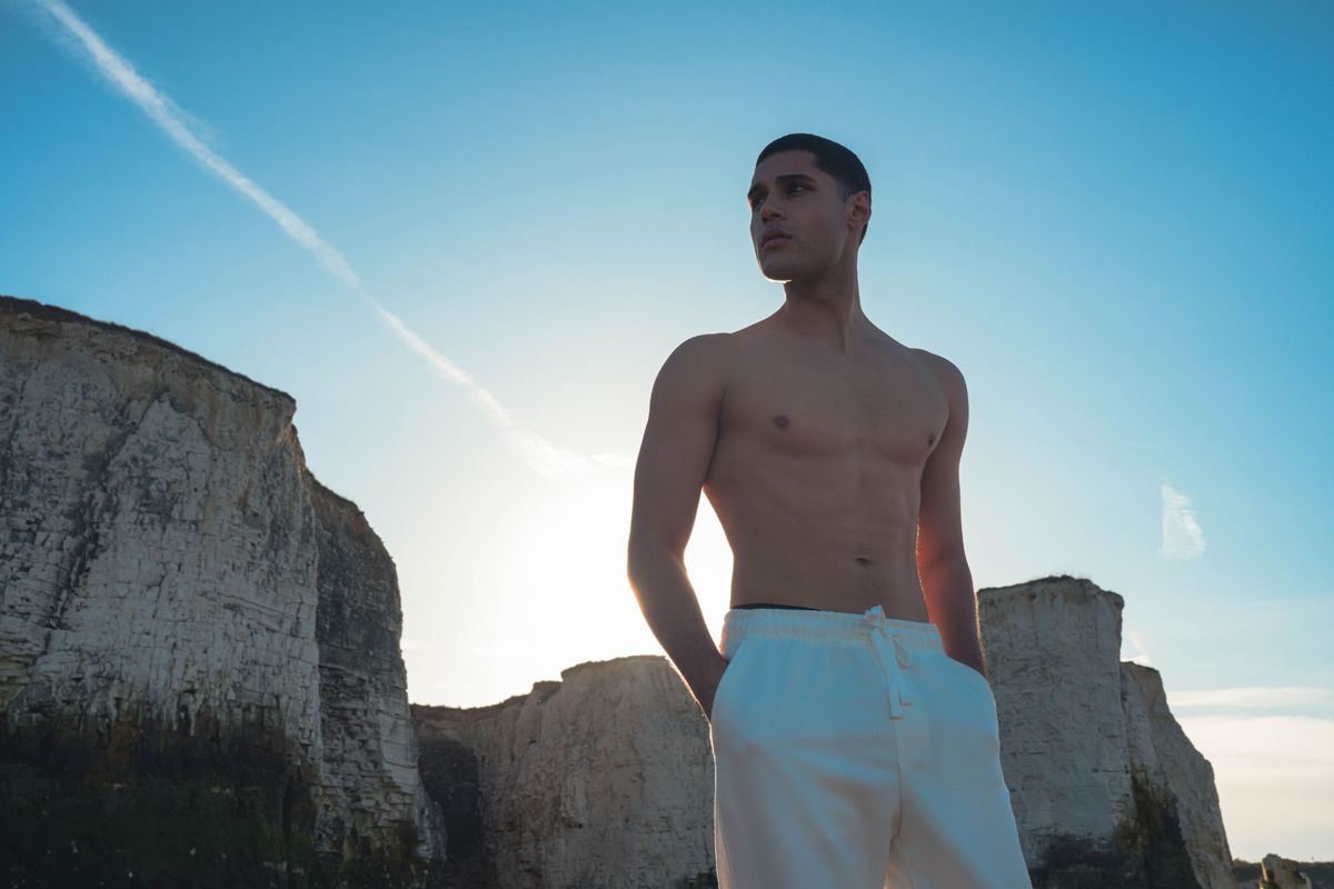 Model in white trousers on the Kent coast with chalk cliffs behind