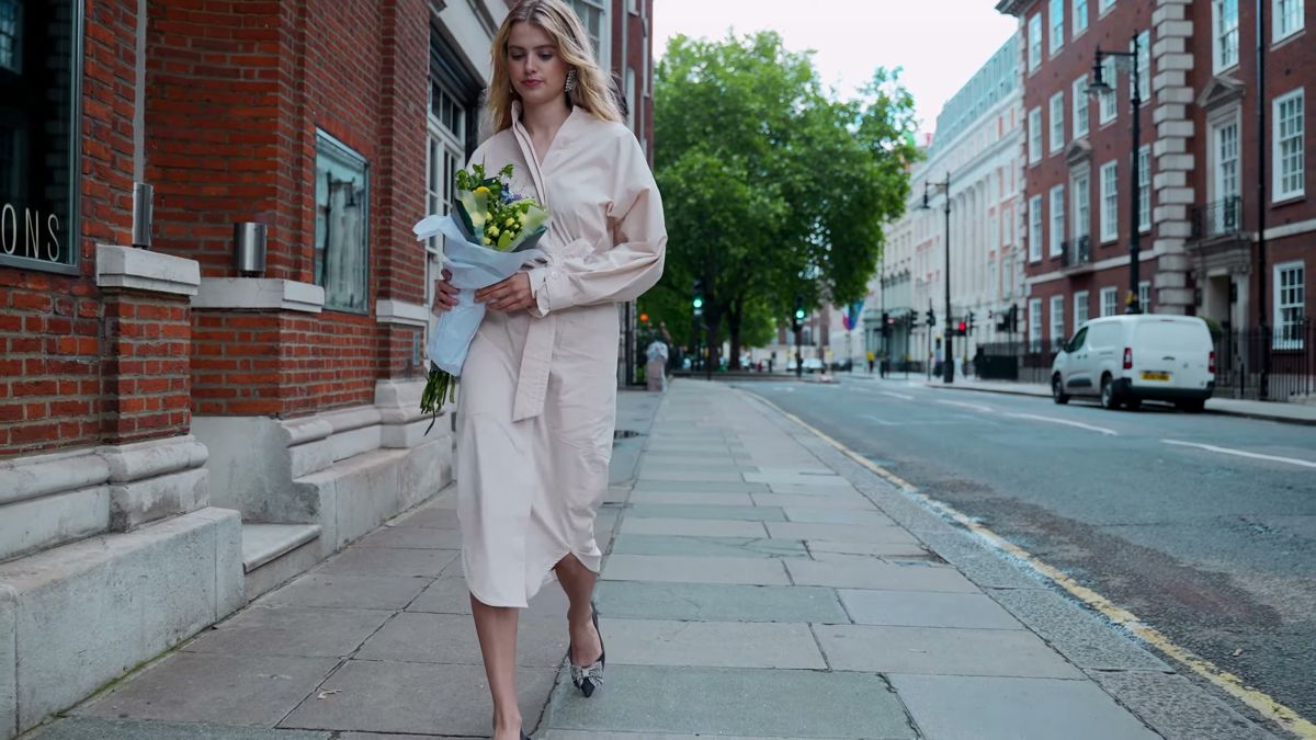Model walking down a quiet London pavement in open shade, Staccato