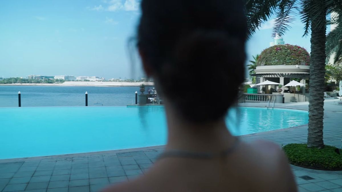 Model seen from behind looking over the pool towards Dubai Creek at Palazzo Versace