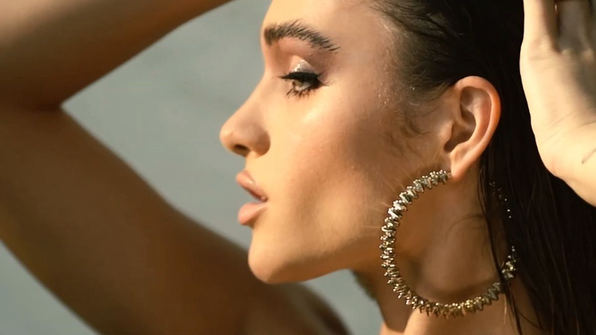 Profile with hoop earring showing contour and glowing skin against a linen backdrop