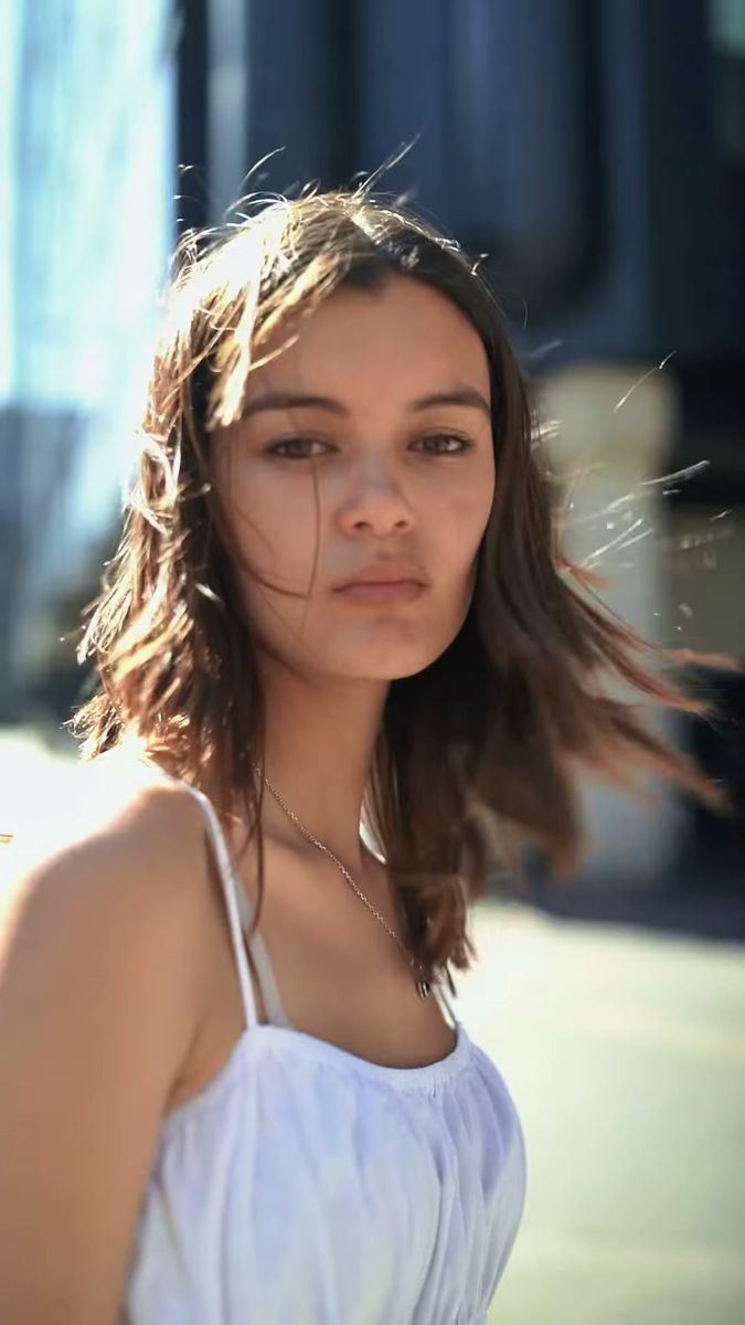 Close portrait of a model with wind in her hair, white dress, London