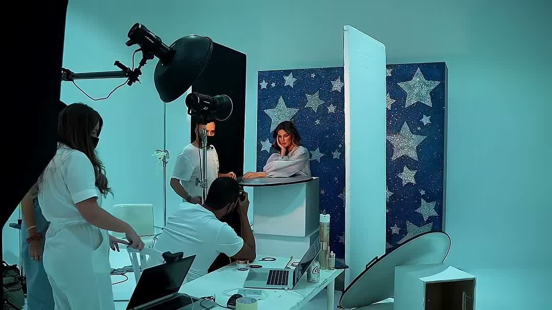 Beauty billboard set in Dubai: strobes with a beauty dish, a photographer, a tethered laptop and the model at a starry backdrop
