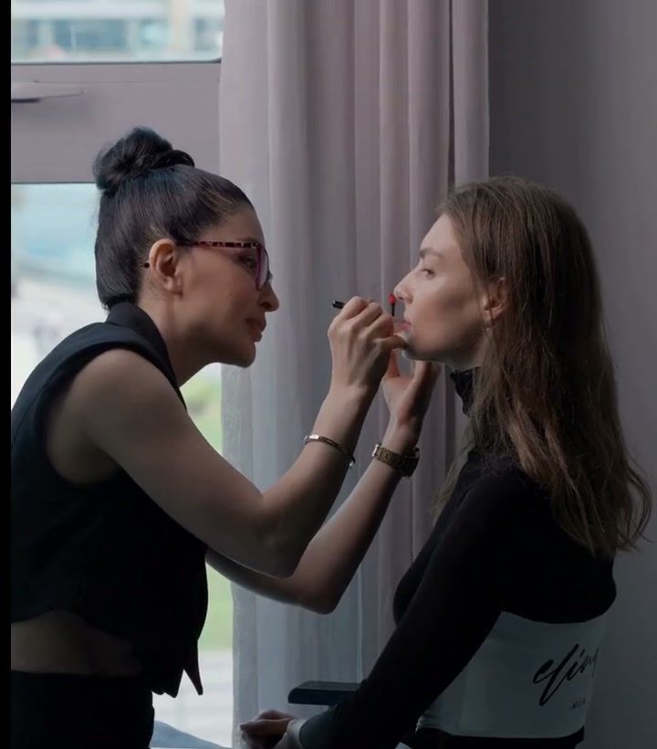 Make-up artist applying a red lip by a window during a beauty editorial in Dubai