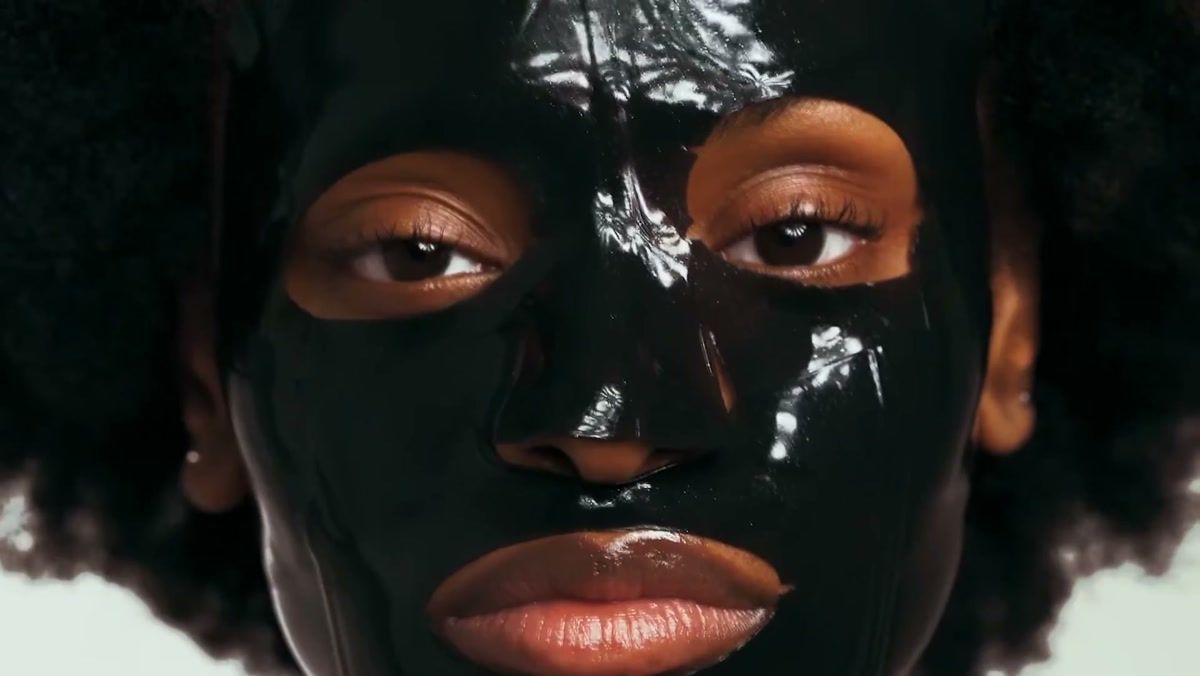 Skincare commercial frame: a glossy black face mask in close-up