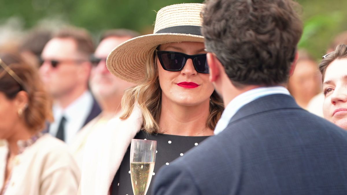 Guests in summer hats with champagne at Chestertons Polo in the Park, London