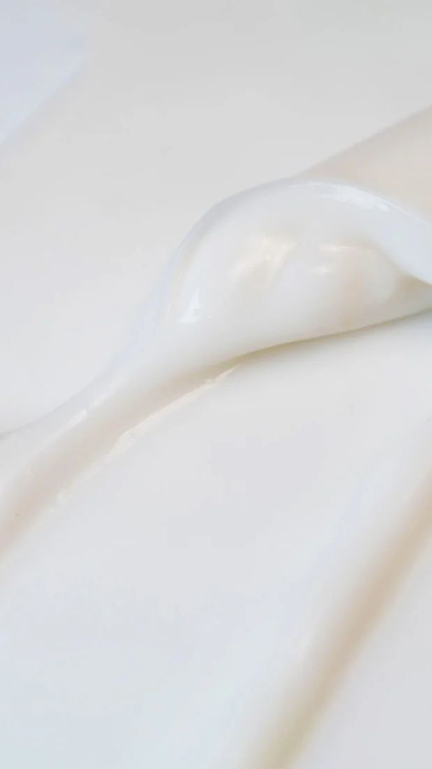 Macro close-up of white skincare cream texture with soft folds