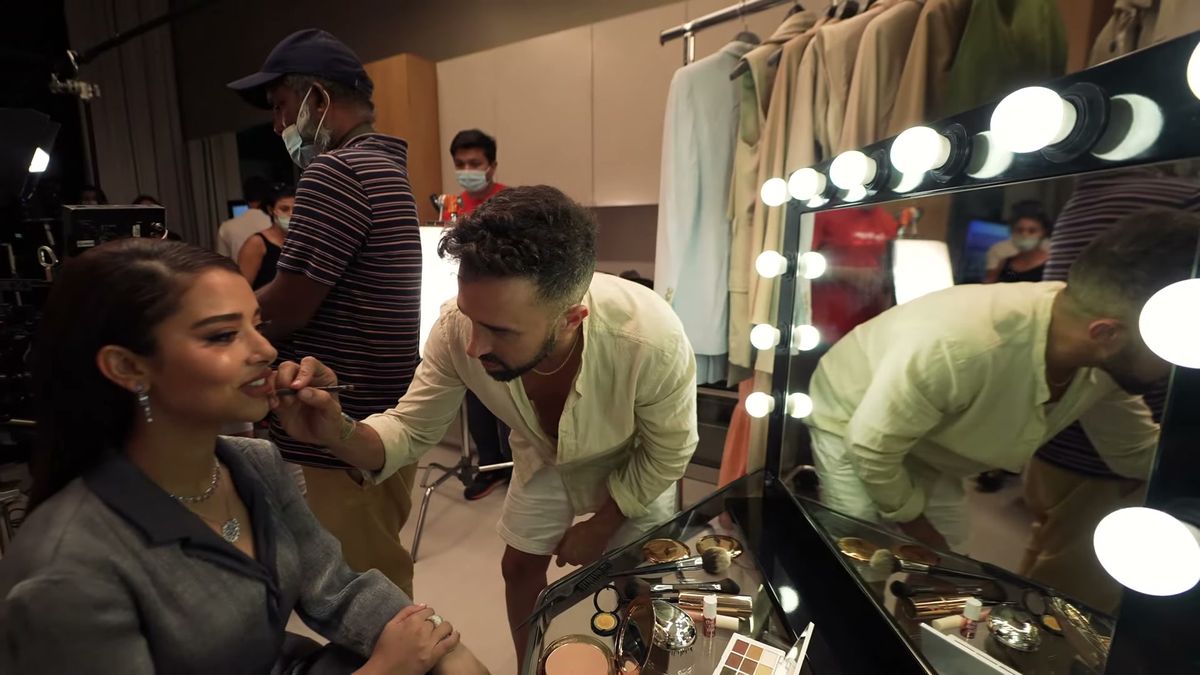 Make-up artist Ido Raphael applies lip colour to Balqees Fathi at a mirror station, Piaget x Vogue Arabia