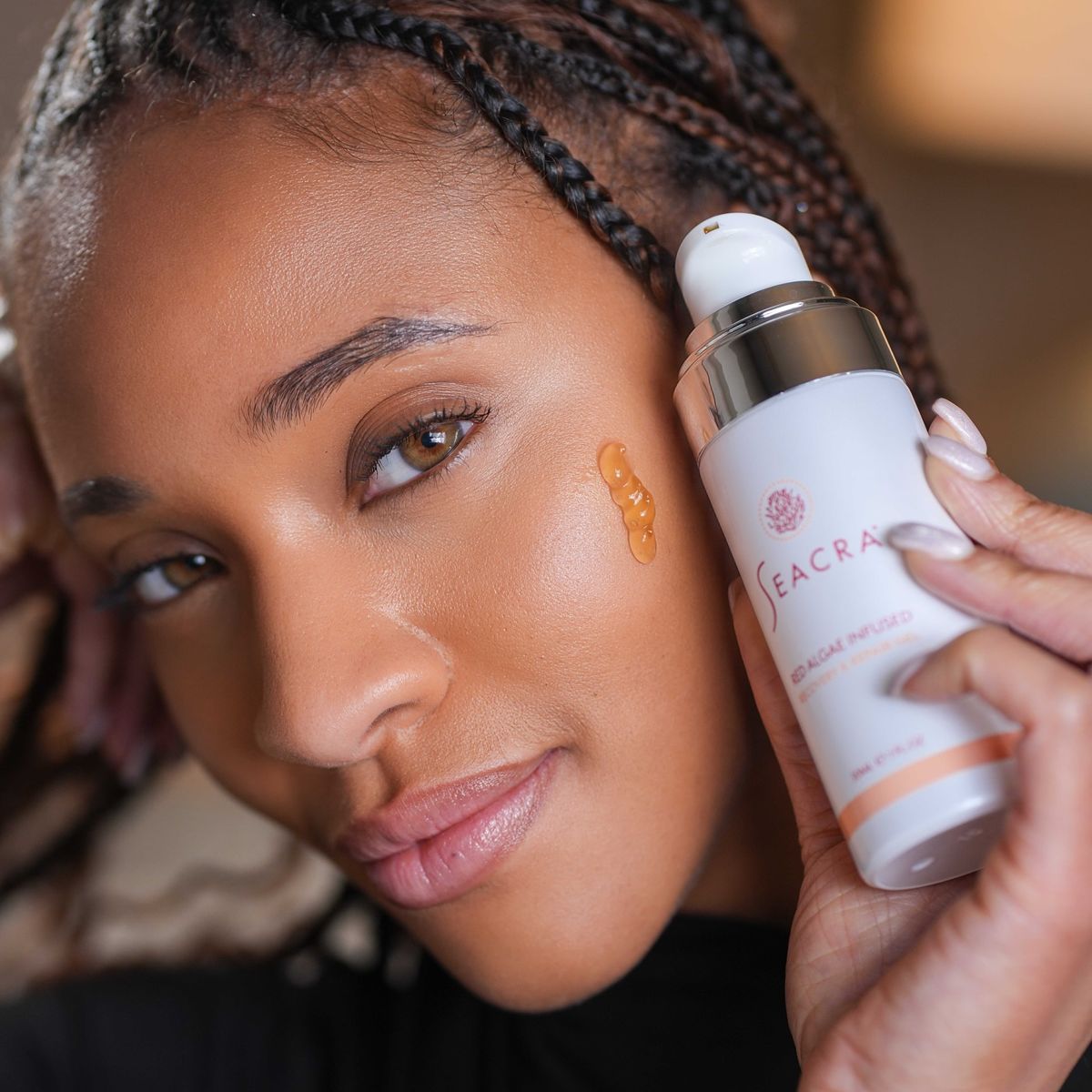 Model holding Seacra Recovery and Repair Gel with the gel on her cheek