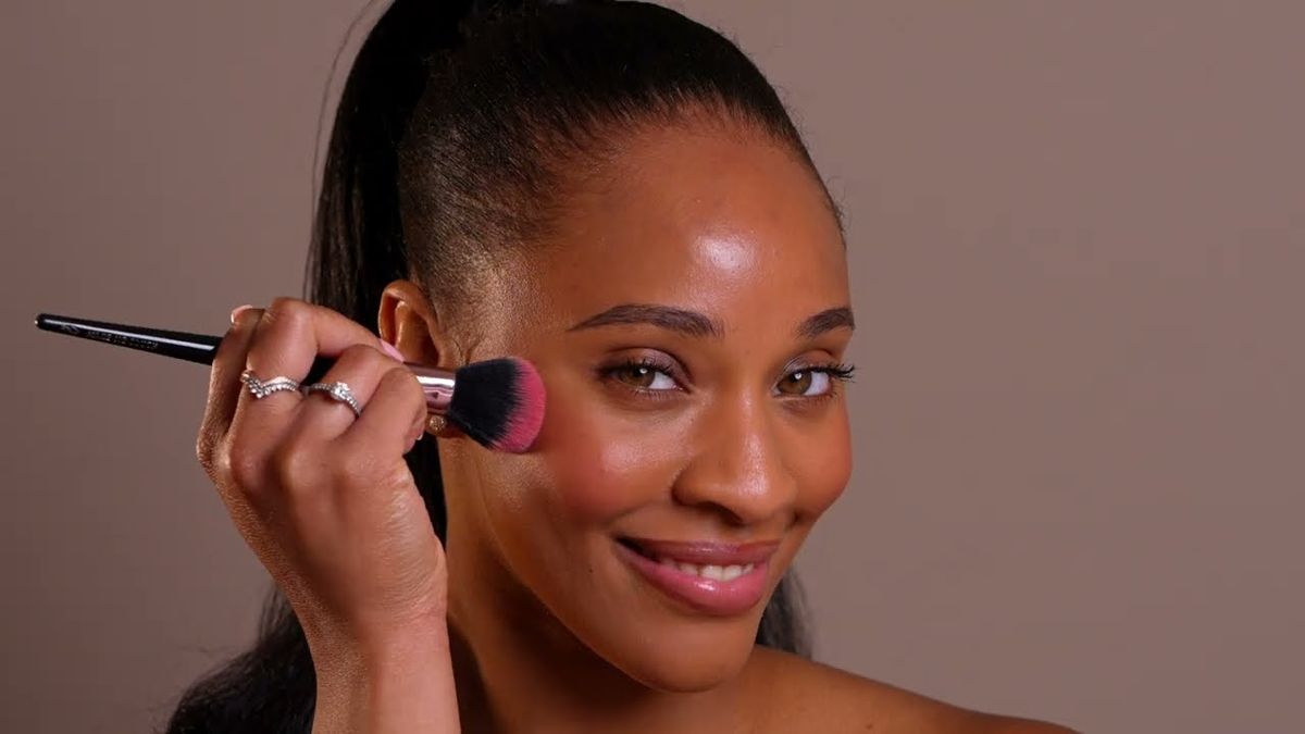 Model applying blush with a brush over prepped skin in the Seacra reset film