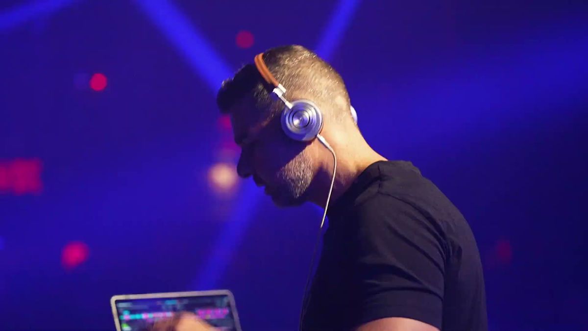 DJ in headphones under blue light at the Affiliate World x Shinz closing party