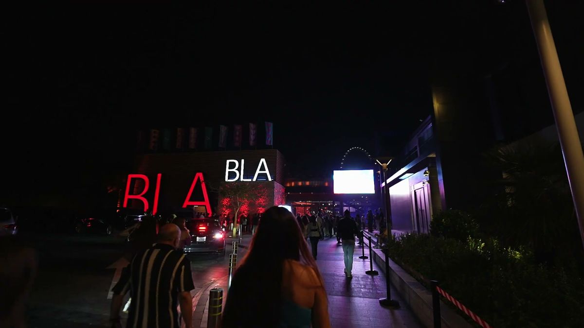 Guests arriving under the Bla Bla sign at night in Dubai