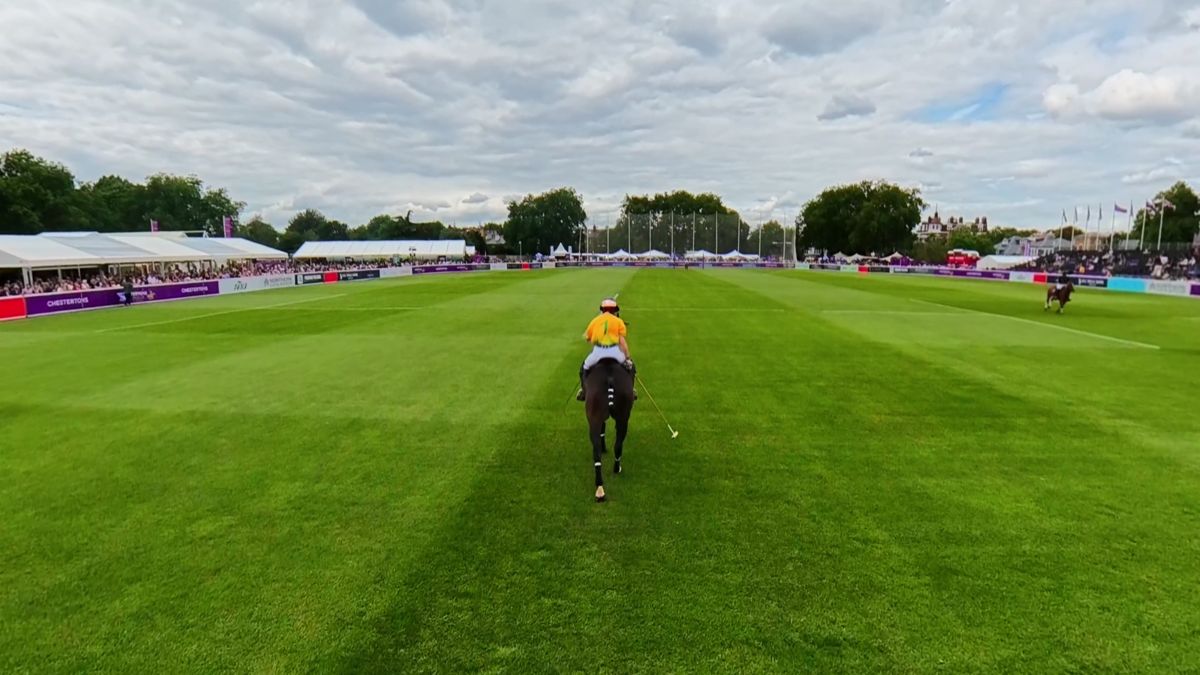 Wide shot following a Team Cape Town rider down the polo pitch