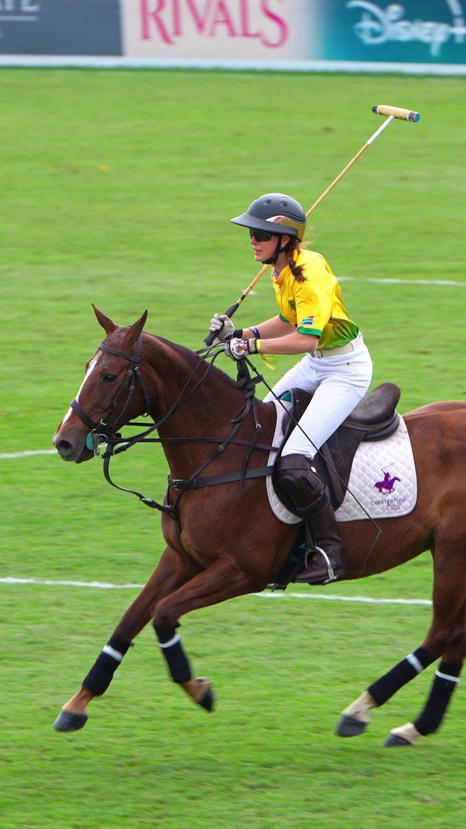 Vertical frame of a Team Cape Town polo player riding with the mallet raised