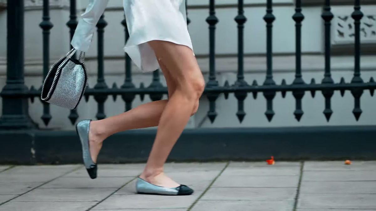 Two-tone ballet flats walking past black railings, everyday look